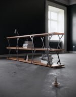 A bookcase with wooden shelves and steel elements that balances with added weight.