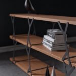A bookcase with wooden shelves and steel elements that balances with added weight.